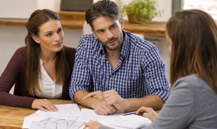 Couple examinant des plans posés sur la table